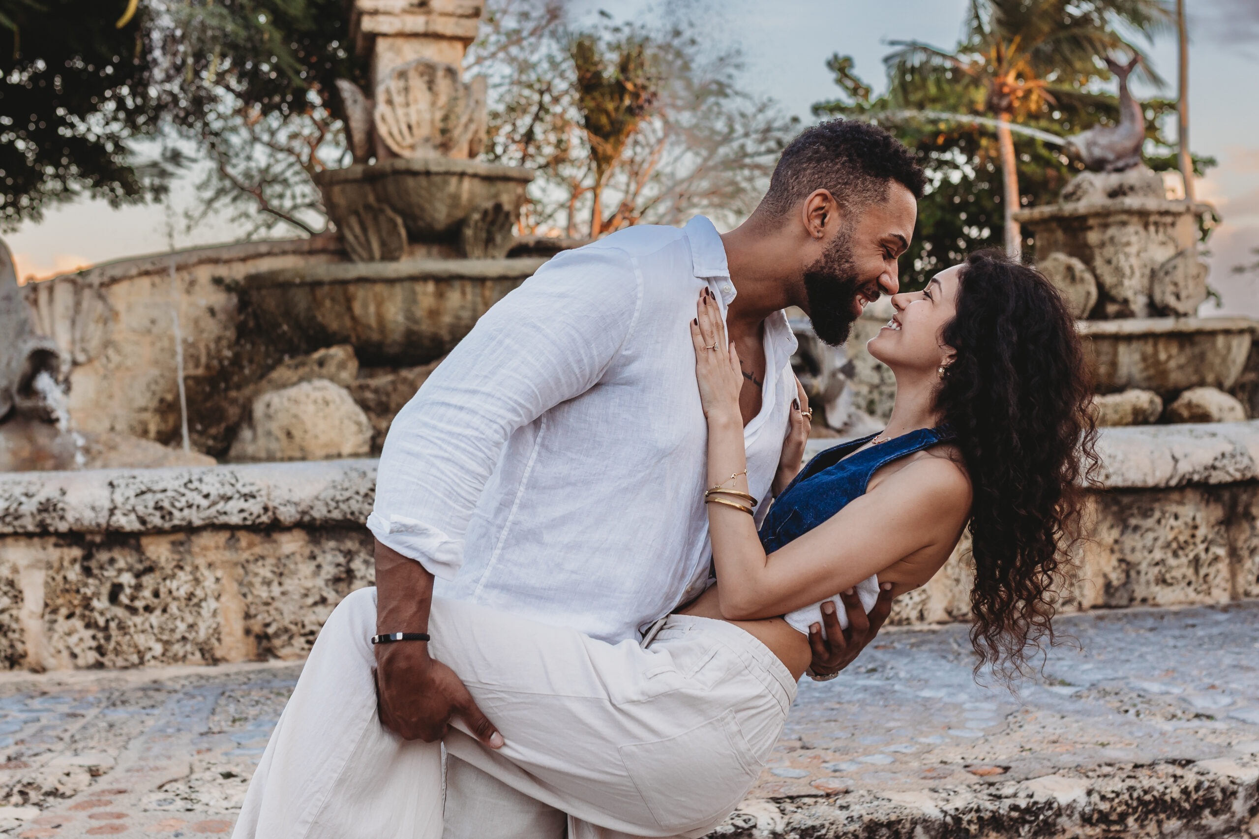Newly engaged couple celebrating with a chilled bottle of premium champagne on the sand, captured by a professional proposal photographer.
