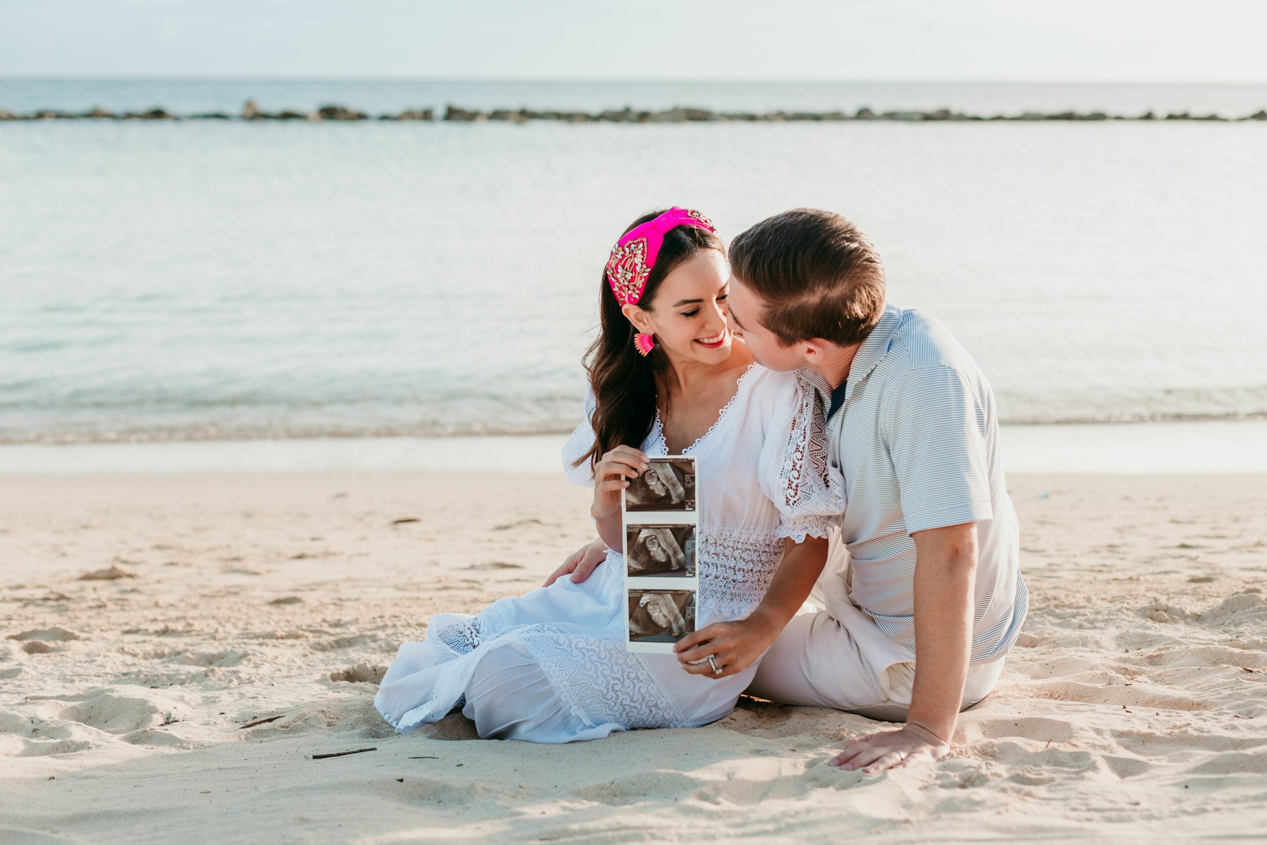 La Romana maternity photographer capturing couple with ultrasound images at Minitas Beach.