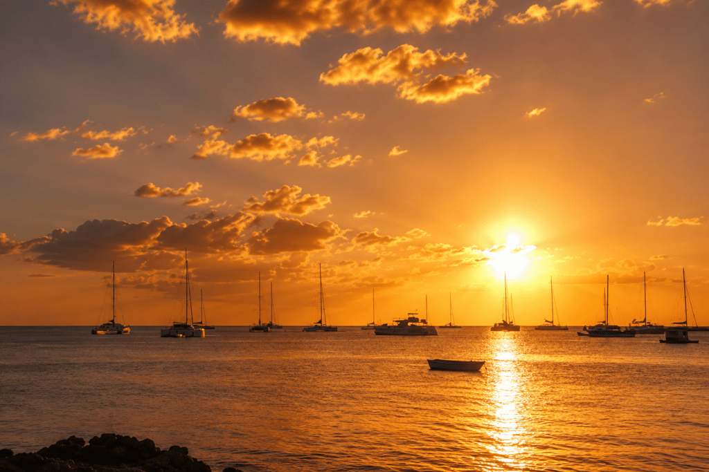 Vibrant golden sunset over calm Caribbean waters with anchored sailboats in Bayahibe near Dreams La Romana, an ideal outdoor photoshoot location captured by a La Romana photographer.