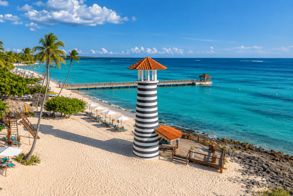 Iconic black-and-white striped lighthouse on the turquoise shoreline of Dominicus Beach in Bayahibe, captured by a La Romana photographer in the Dominican Republic.