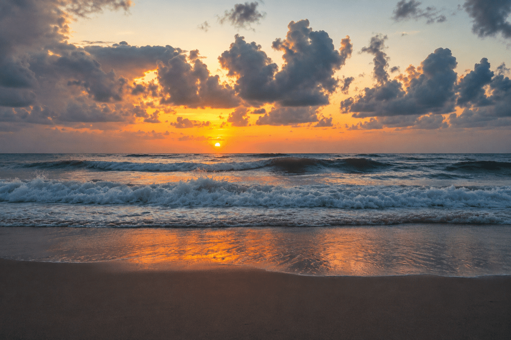 Golden sunset sky reflecting over crashing ocean waves on the beach in Juan Dolio, an outdoor photoshoot location captured by a La Romana photographer.