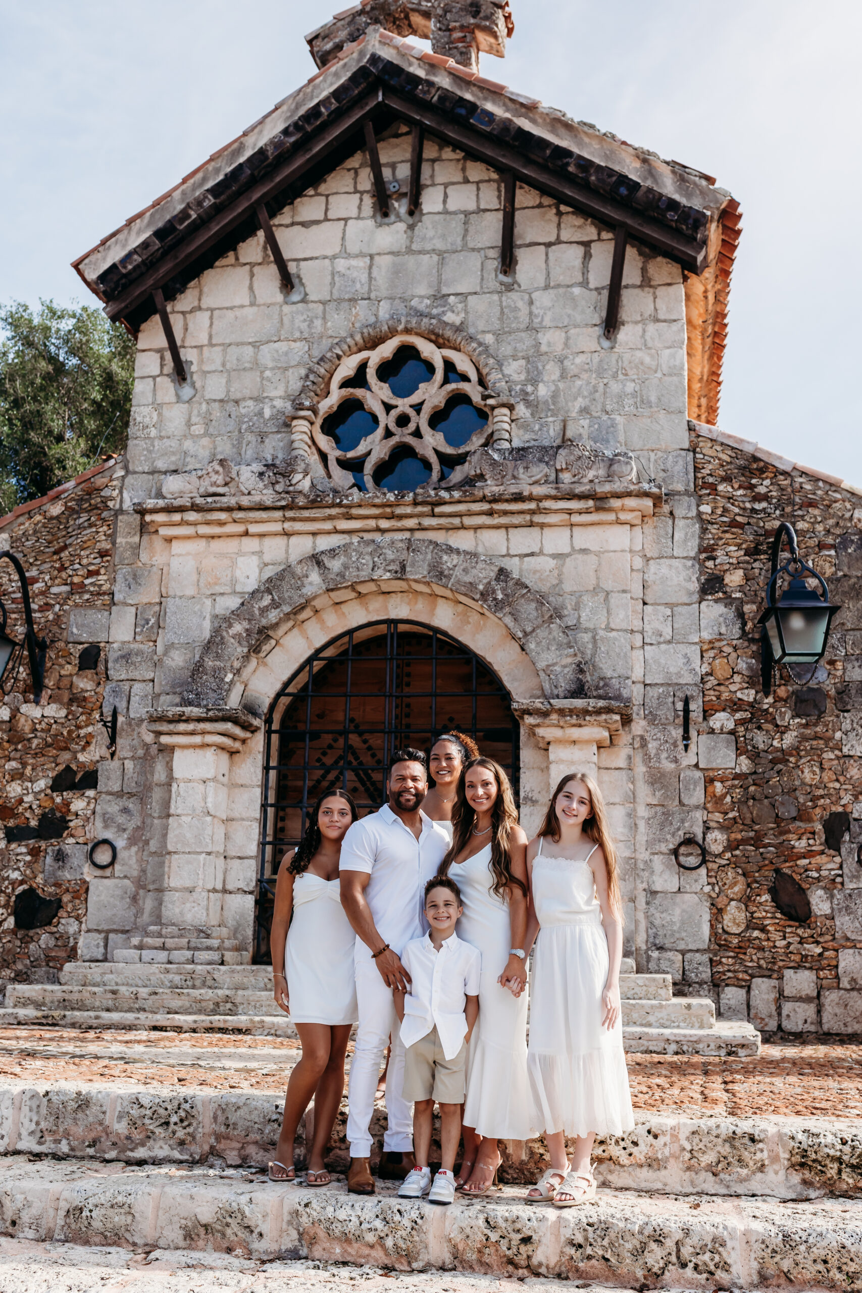Family gathered for a photoshoot in front of the stone church at Altos de Chavón, Casa de Campo.