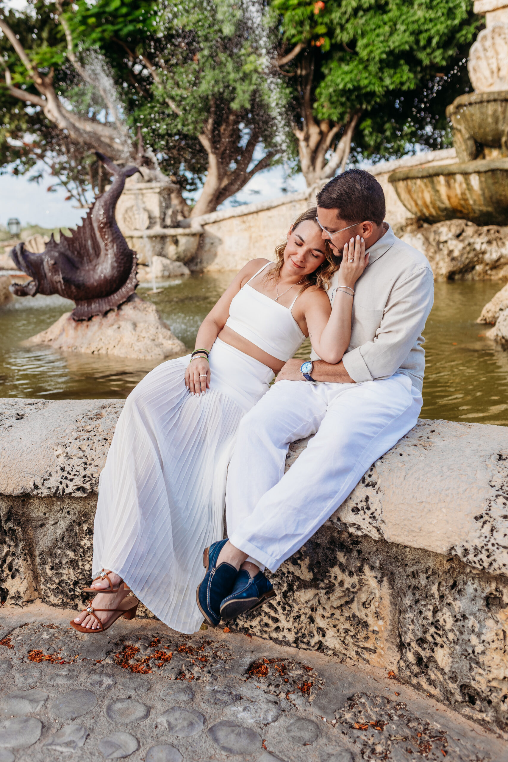Engaged couple together by a garden water feature in Altos de Chavón, Casa de Campo, La Romana.